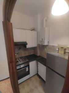 a small kitchen with a stove and white cabinets at SWEET HOUSE dolce casa in Campomorone