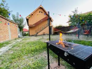a grill with a fire in a yard at Central Apartment in Blaj
