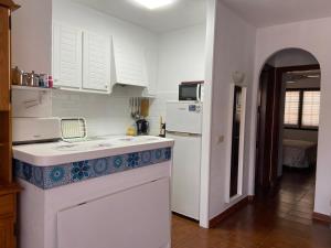 a kitchen with white cabinets and a counter top at Siestamar in Cala en Porter