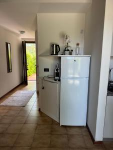 a kitchen with a white refrigerator in a room at Casa Conchiglia - Aprilia Marittima - Corte Grande in Aprilia Marittima