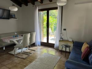 a living room with a table and a blue couch at Casa Conchiglia - Aprilia Marittima - Corte Grande in Aprilia Marittima
