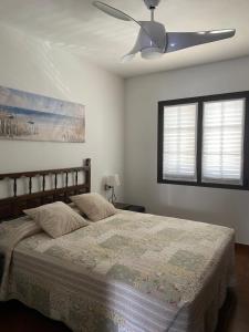 a bedroom with a bed with a ceiling fan at Siestamar in Cala en Porter