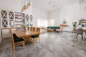 a large living room with a table and chairs at לה וילא - וילה מדהימה עם בריכה פרטית וג'קוזי in Sderot