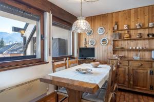 a dining room with a table and a tv at Appartamento Vittoria in Cavalese