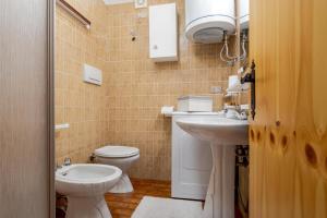 Un baño pequeño con inodoro y lavabo. en Appartamento Vittoria, en Cavalese 11 fotos más