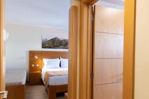 um quarto com uma cama e uma porta para um quarto em Hotel Berne em Manteigas