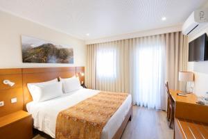 um quarto de hotel com uma cama e uma escrivaninha em Hotel Berne em Manteigas mais 35 fotografias