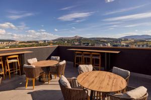 a patio with tables and chairs on a roof at Bor Hotel by Karisma in Zlatibor