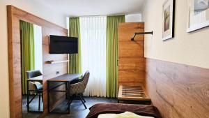 a hotel room with a desk and a television at Gasthof Alte Schule in Fürstenzell