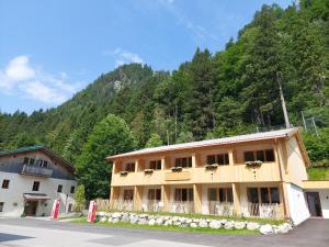 a building in front of a mountain with trees at Hotel Gasthof Klause Dependance 2 in Reutte