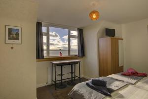 a bedroom with a bed and a desk and a window at Kavija, Invergordon in Invergordon