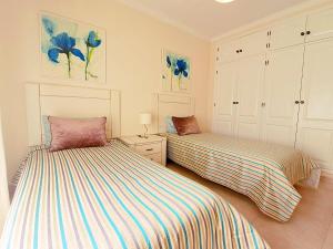 two beds sitting next to each other in a bedroom at Apartamento Oásis Parque 1 in Portimão +47 photos