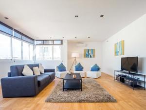 a living room with a couch and a tv at Rent Top Apartments Rambla Catalunya in Barcelona