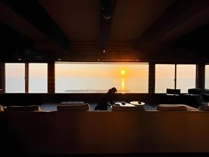 a person in a room with chairs and a window at Moonbay Beach Villa in Lake Toya