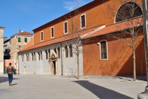a man walking down a street in front of a building at Apartment Eva in Zadar