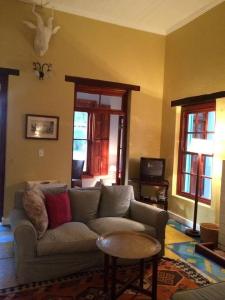 a living room with a couch and a table at Murrayfield Karoo Guest Villa in Nieu-Bethesda