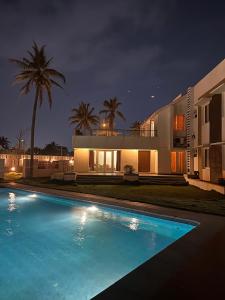 a swimming pool in front of a house at night at Villa Bay by Youkoso in Chennai