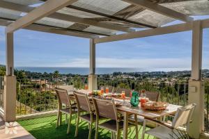 einen Esstisch und Stühle auf einer Terrasse mit Aussicht in der Unterkunft Villa Begonia by Abahana Villas in Fanadix