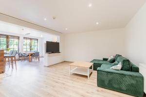 a living room with a green couch and a table at Apartament nad Dzikim Potokiem in Karpacz
