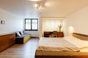a bedroom with a bed and a desk and a couch at Apartament nad Dzikim Potokiem in Karpacz