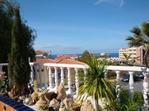 una casa blanca con una valla y palmeras en Luxurious Violet Villa, en Adeje