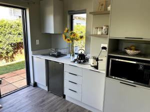 a kitchen with white cabinets and a stove top oven at Cozy Nook in Noordhoek in Harmony