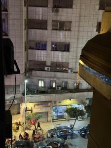 a view of a building with a parking lot with cars at غرفة أنيقة في قلب القاهرة in Cairo