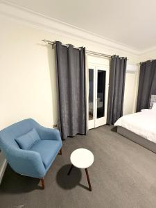 a bedroom with a bed and a blue chair and a table at غرفة أنيقة في قلب القاهرة in Cairo +20 photos