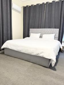 a bedroom with a large white bed with black curtains at غرفة أنيقة في قلب القاهرة in Cairo