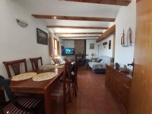 a dining room and living room with a table and chairs at Candela de la Murtera in Chelva