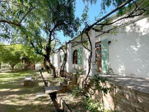 a building with a group of benches in the yard at Murrayfield Karoo Guest Villa in Nieu-Bethesda
