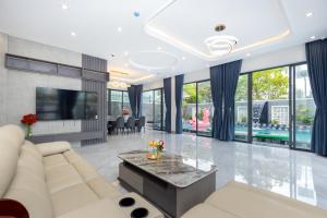 a living room with a white couch and a tv at B2-34 Hoàng My Villa in Vung Tau