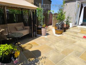 patio con piante in vaso e divano di Rustic Harmony - Edinburgh Airport near, 8mi a Rosyth