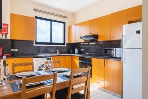 a kitchen with a table and a white refrigerator at CityDen in Larnaka +10 photos