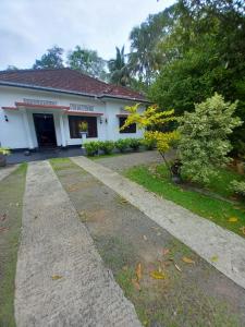 a white house with a driveway in front of it at Amith Villa Kabalana in Piyadigama
