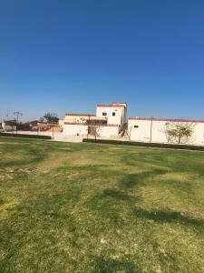 a field of grass with a building in the background at Lake view resort bikaner in Bikaner