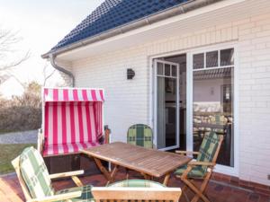 a patio with a wooden table and chairs on a porch at Ferienwohnung Julian in Hörnum