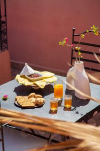 a table with a tray of food and two glasses of orange juice at RIAD PRIVATIF avec Piscine Chauffée au Cœur de la Médina et Petits-Déjeuners Inclus in Marrakech +54 photos