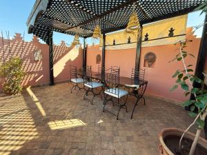 a patio with a table and chairs on it at RIAD PRIVATIF avec Piscine Chauffée au Cœur de la Médina et Petits-Déjeuners Inclus in Marrakech
