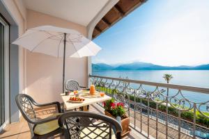 a balcony with a table and an umbrella at Residence Casa e Vela in Oggebbio