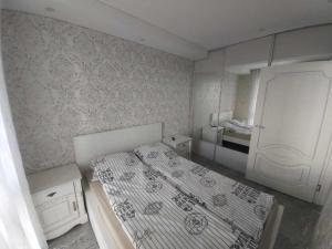 a small bedroom with a bed and a refrigerator at Gilužio Apartments in Vilnius