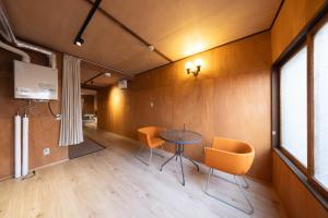 Una habitación con una mesa y sillas y una ventana. en Ura Otaru Montparnasse Inn, en Otaru 10 fotos más