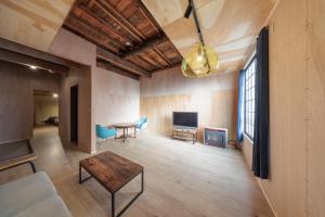 Una sala de estar con una mesa y un televisor. en Ura Otaru Montparnasse Inn, en Otaru