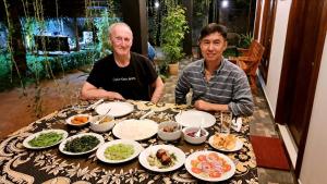 two men sitting at a table with plates of food at Hotel Awaken in Dambulla +29 photos
