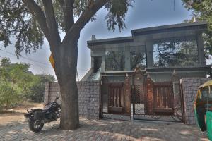 ein Motorrad, das vor einem Zaun mit einem Haus parkt in der Unterkunft Hotel Ramayan Premium Best Family Hotels with Free Pickup From Ayodhya Dham Railway Station in Ayodhya