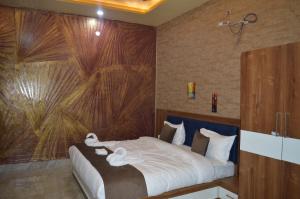 a bedroom with a bed with a large painting on the wall at Hotel AshokA in Etah
