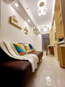 a room with a couch with pillows on it at S Residences 942b near airport pasay in Manila