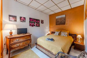 a bedroom with a bed and a desk with a television at La Palmeraie 300m plage, calme in Arcachon