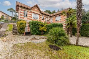 a house with a gate in front of a yard at La Palmeraie 300m plage, calme in Arcachon