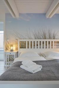 two beds in a bedroom with two white beds at Entspannt Urlauben am Wasser Ferienhaus "Schuppen 23" für bis zu vier Personen! in Borgwedel